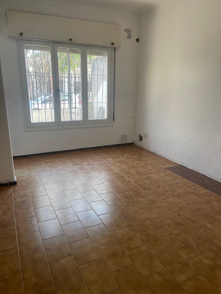 CASA EN ALQUILER. Dos dormitorios. Cochera. Patio con cesped. Parrillero. Laprida 4600